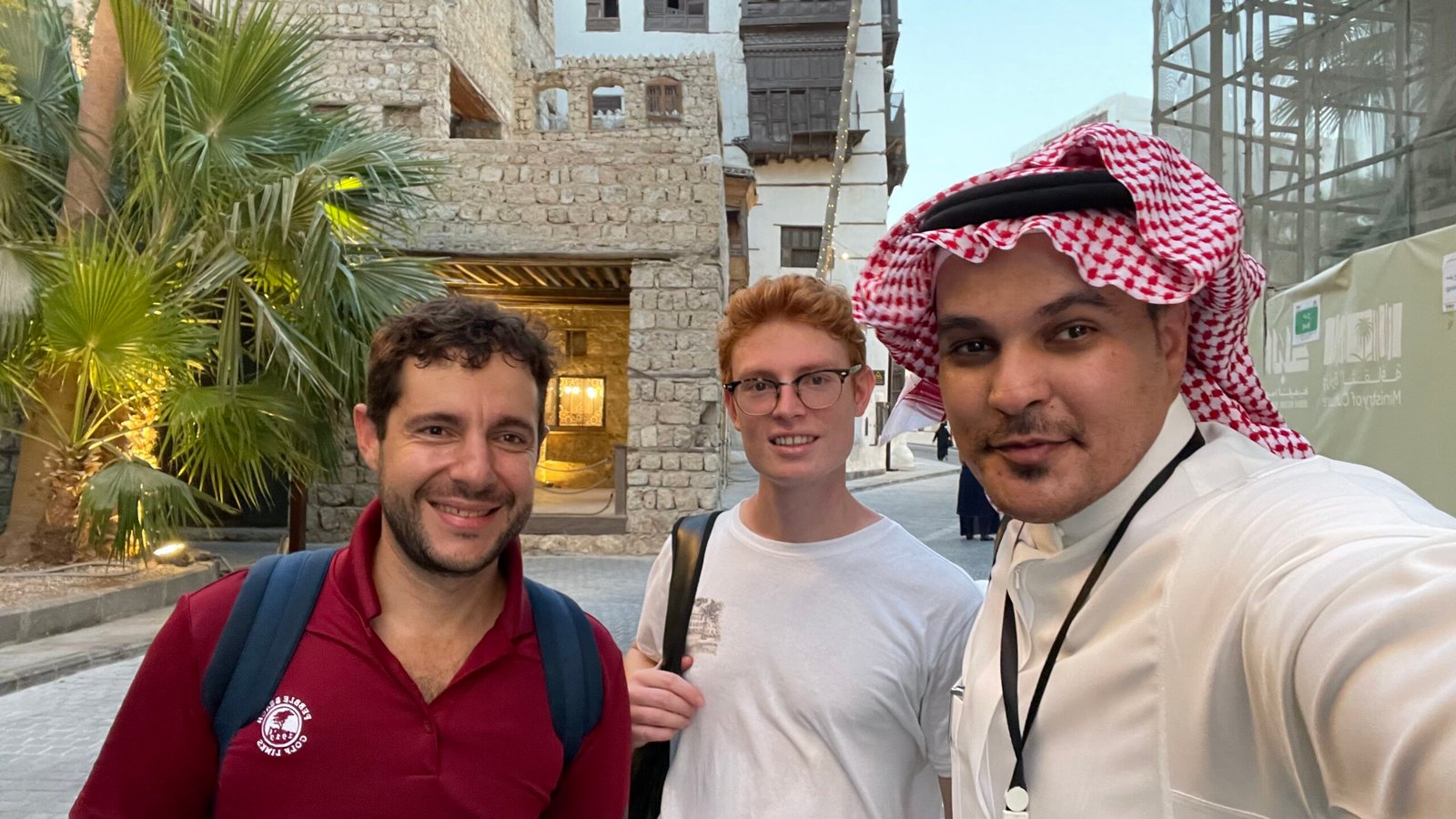 عادل السلمي مع زائرين أمام مبانٍ تراثية خلال جولة