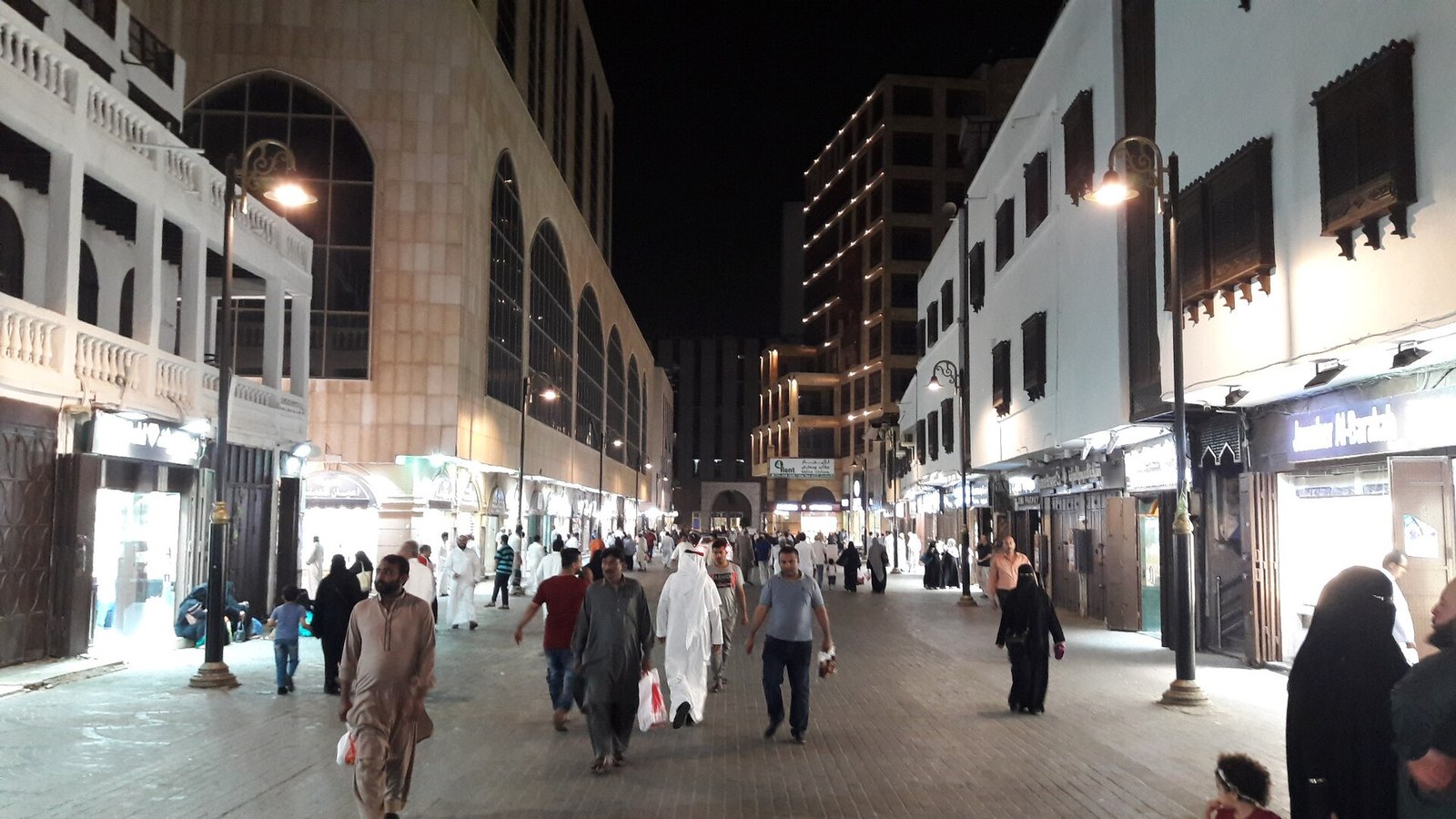 زوار يمشون في شوارع جدة البلد مساءً