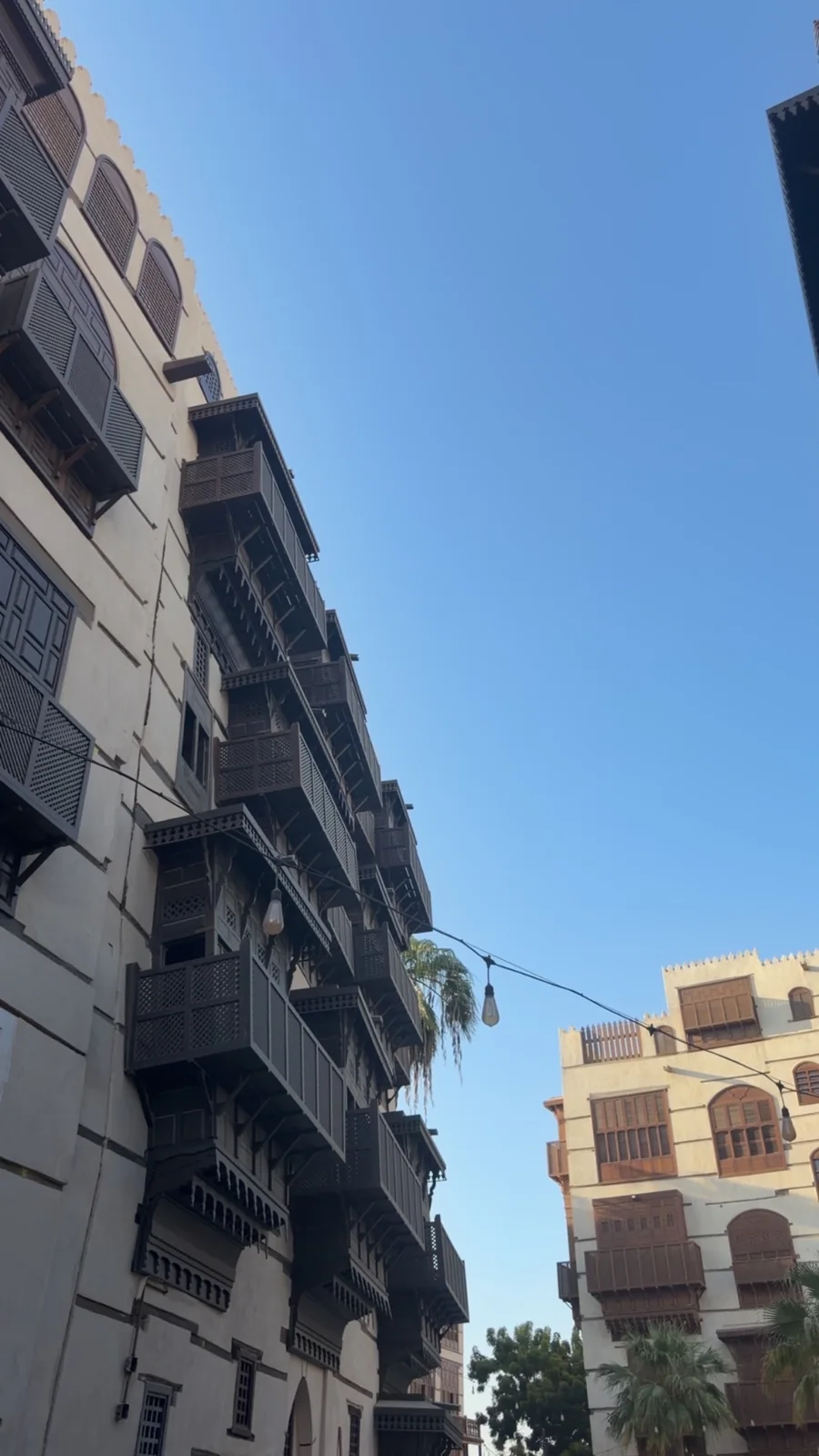 رواشين داكنة ومبانٍ تراثية تحت سماء زرقاء