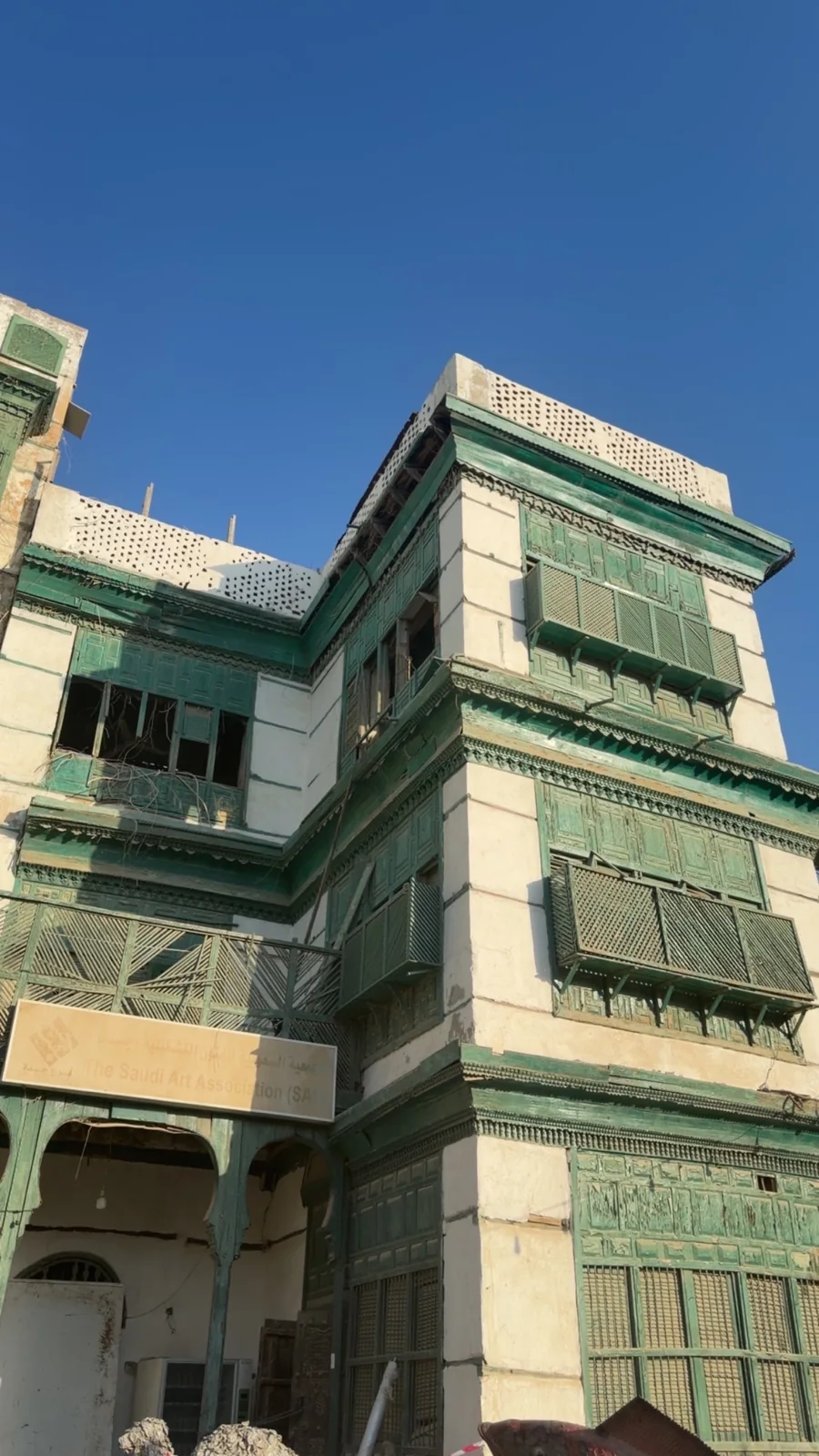 رواشين خشبية خضراء على واجهة مبنى تراثي